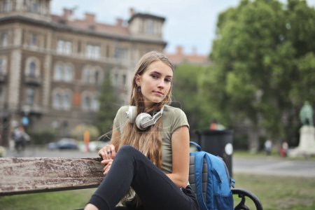 Photo for Young woman sitting on a bench in the city - Royalty Free Image