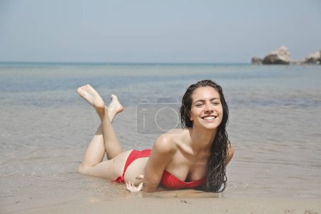 Foto de Joven hermosa mujer acostada en la playa - Imagen libre de derechos