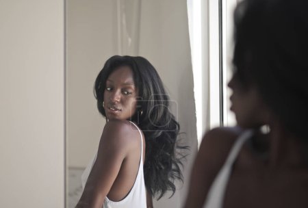 Foto de Joven mujer se prepara mirando en el espejo - Imagen libre de derechos