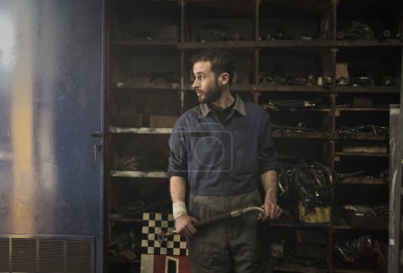 Téléchargez les photos : Jeune mécanicien dans son atelier - en image libre de droit