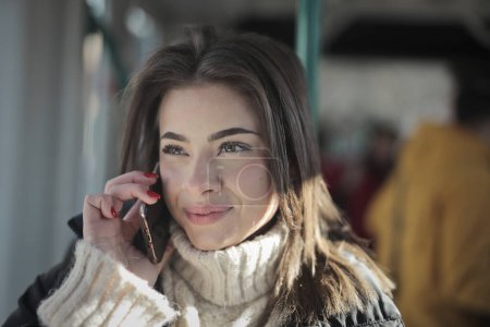 Foto de Mujer joven habla por teléfono en un tranvía - Imagen libre de derechos
