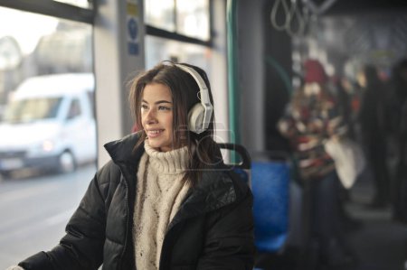 Foto de Mujer joven escucha música en el tren - Imagen libre de derechos