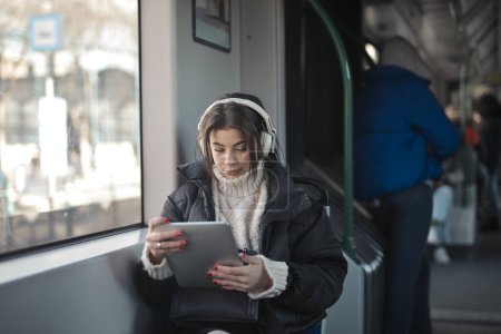 Foto de Joven mujer escucha música en el tren desde una mesa - Imagen libre de derechos