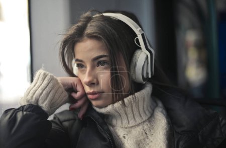Téléchargez les photos : Jeune femme écoute de la musique dans le train - en image libre de droit