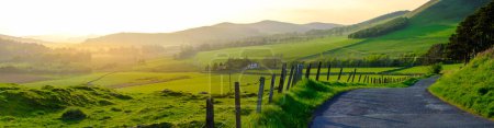 Photo for Panorama Of A Single-Track Road Snaking Through The Beautiful Scottish Countryside At Sunset - Royalty Free Image