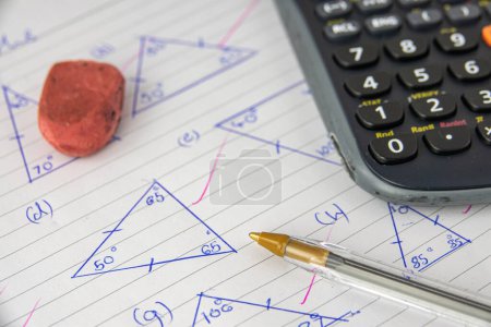 Foto de La tarea o el examen de matemáticas (geometría) de un niño, con calculadora, pluma y borrador - Imagen libre de derechos