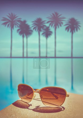 Vacation Image Of Expensive Sunglasses By A Pool At A Tropical Resort With Palm Trees