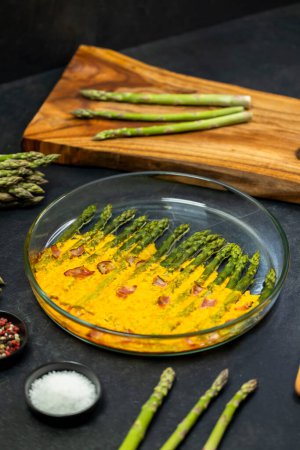 Photo for Green asparagus baked with chedar cheese and parma ham - Royalty Free Image