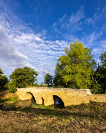 Foto de Puente románico de Artigue y río Osse cerca de Larressingle en ruta a Santiago de Compostela, Patrimonio de la Humanidad por la UNESCO, departamento Gers, Francia - Imagen libre de derechos