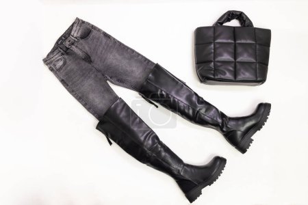 Téléchargez les photos : Nature morte de jeans gris, bottes noires et sac à main noir - en image libre de droit