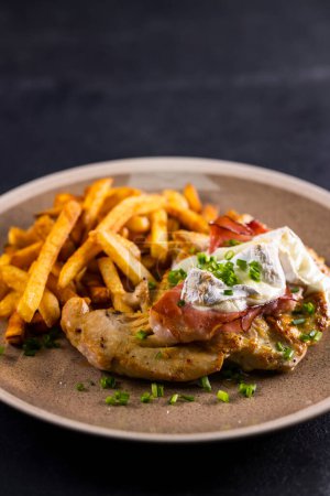 Photo for Typical czech cuisine chicken slice baked with ham and camembert with french fries - Royalty Free Image