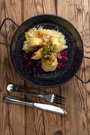 Photo for Dumpllings filled with smoked meat served with red and white cabbage - Royalty Free Image