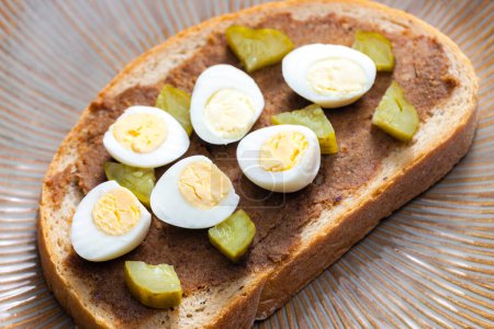 Foto de Cracklings spread with pickled cucumber and boiled egg on slice of bread - Imagen libre de derechos
