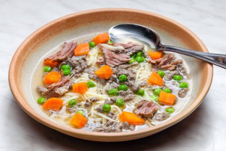 Photo for Beef broth with green peas, carrot and small meatballs - Royalty Free Image