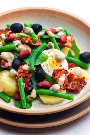 Foto de Ensalada de judías verdes y rojas con aceitunas negras, espinacas, huevo cocido y tocino - Imagen libre de derechos