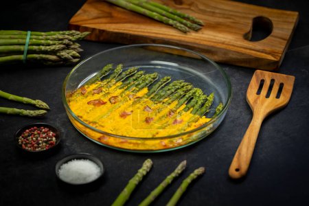Photo for Green asparagus baked with chedar cheese and parma ham - Royalty Free Image