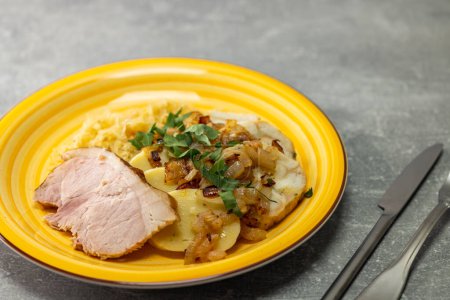 Foto de Pork meat with potato dumplings and pickled cabbage served with roasted onion - Imagen libre de derechos