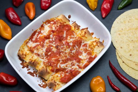 Foto de Burritos baked with tomato sauce and cheddar cheese - Imagen libre de derechos