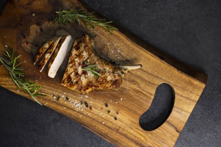 Téléchargez les photos : Pork cutlet with a bone on rosemary and pepper - en image libre de droit