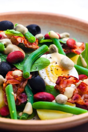Photo for Salad of green and red beans with black olives, spinach, boiled egg and bacon - Royalty Free Image