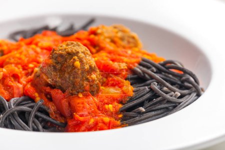 Téléchargez les photos : Spaghetti noir à la sauce tomate aux boulettes de viande - en image libre de droit