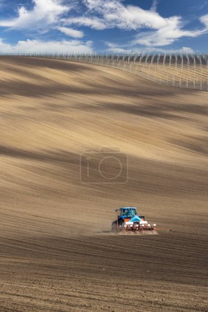 Photo for Tractor with seed drill in early spring landscape - Royalty Free Image