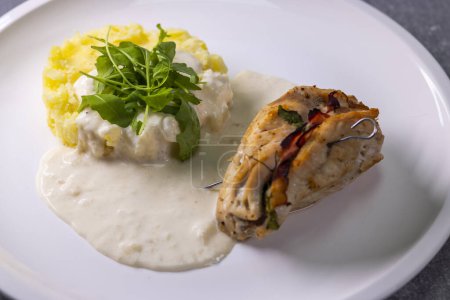Photo for Turkey roll filled with spinach and ham served with mashed potatoes and cream sauce - Royalty Free Image