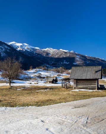 Téléchargez les photos : Typical landscape with wooden log cabins near Bohinjska Bistrica, Triglavski national park, Slovenia - en image libre de droit