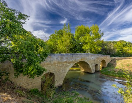 Photo for Romanesque bridge of Artigue and river Osse near Larressingle on route to Santiago de Compostela, UNESCO World Heritage Site, departement Gers, France - Royalty Free Image