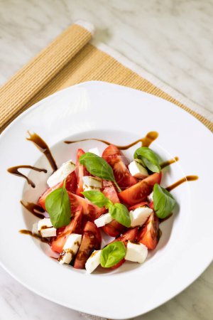 Foto de Tomato salad with mozzarella, basil and balsamic cream - Imagen libre de derechos