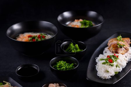 Téléchargez les photos : Divers plats de la cuisine asiatique avec différents types de nouilles et de riz aux crevettes, légumes et sésame noir - en image libre de droit