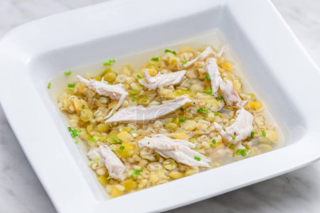 Photo for Broth with chicken meat, barley groats and yellow peas - Royalty Free Image