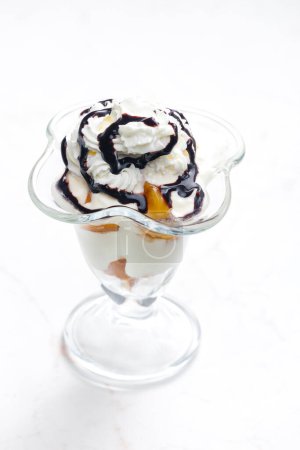 Photo for Ice cream with stewed peach and whipped cream - Royalty Free Image