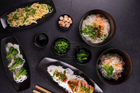 Photo for Various dishes of Asian cuisine with different types noodles and rice with shrimp, vegetables and black sesame - Royalty Free Image