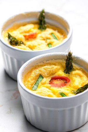 Photo for Baked eggs with green asparagus, tomato and spring onion - Royalty Free Image
