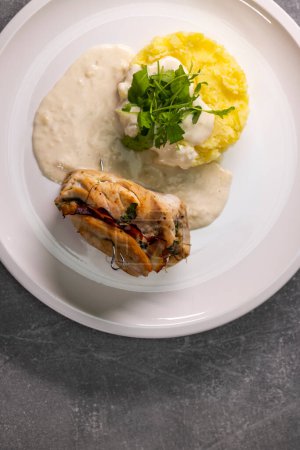 Téléchargez les photos : Rouleau de dinde rempli d'épinards et de jambon servi avec purée de pommes de terre et sauce à la crème - en image libre de droit