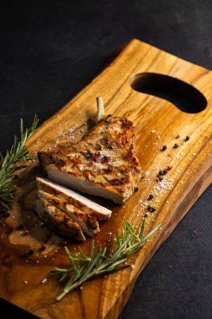 Téléchargez les photos : Pork cutlet with a bone on rosemary and pepper - en image libre de droit
