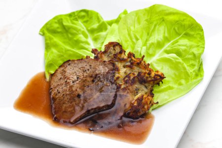 Téléchargez les photos : Steak de bœuf avec sauce servi avec des pankcakes aux pommes de terre - en image libre de droit