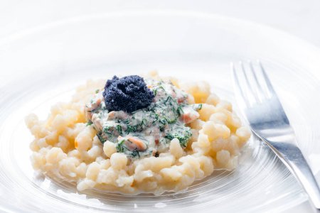Téléchargez les photos : Halusky au saumon et sauce à l'aneth servi avec du caviar noir - en image libre de droit