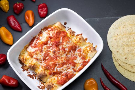 Photo for Burritos baked with tomato sauce and cheddar cheese - Royalty Free Image