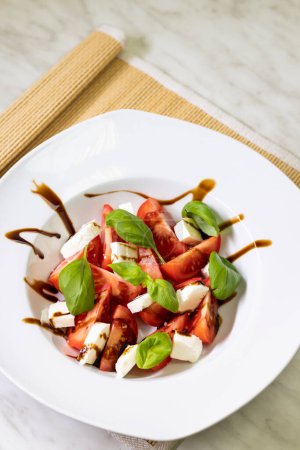 Téléchargez les photos : Salade de tomates à la mozzarella, basilic et crème balsamique - en image libre de droit