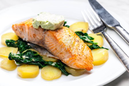 Photo for Baked salmon with spinach leaves and potatoes - Royalty Free Image