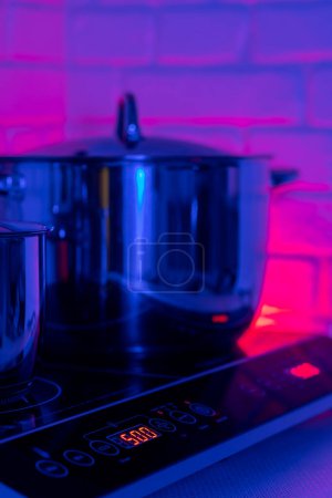 Téléchargez les photos : Pot en métal sur plaque à induction dans la cuisine moderne - en image libre de droit
