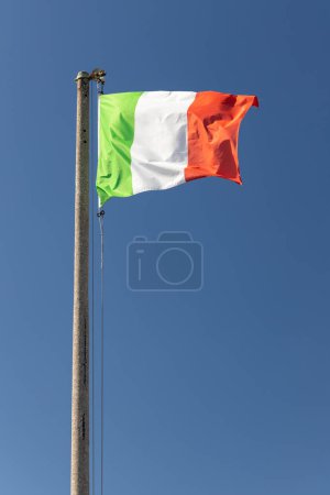 Foto de Bandera de Italia soplando en el viento en el cielo azul - Imagen libre de derechos