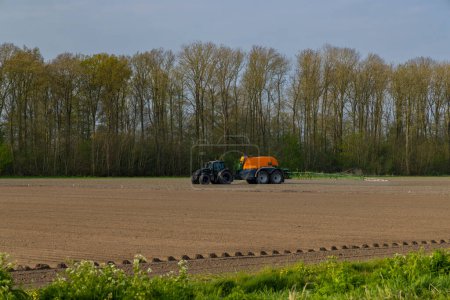 Photo for Tractor with sprayer during spring work on the field - Royalty Free Image
