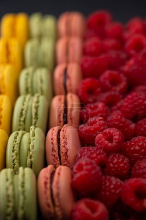 Foto de Macarrones de diferentes colores con frambuesas - Imagen libre de derechos