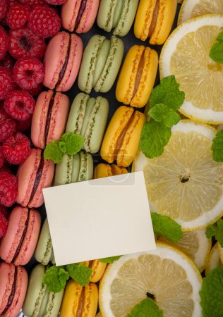 Foto de Macarrones de diferentes colores con frambuesas, limón y menta - Imagen libre de derechos
