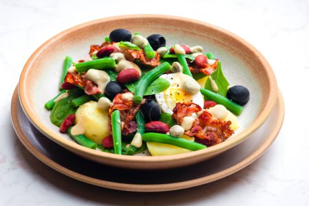 Photo for Salad of green and red beans with black olives, spinach, boiled egg and bacon - Royalty Free Image