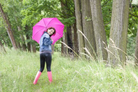 Foto de Mujer con botas de goma con paraguas en la naturaleza de primavera - Imagen libre de derechos