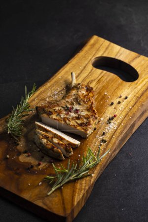 Photo for Pork cutlet with a bone on rosemary and pepper - Royalty Free Image
